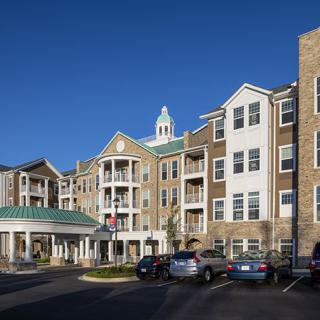 Exterior view of a residential apartment complex with parked cars.