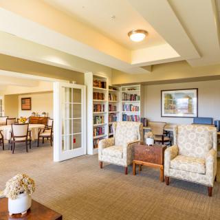 A spacious living room with comfortable seating and bookshelves.