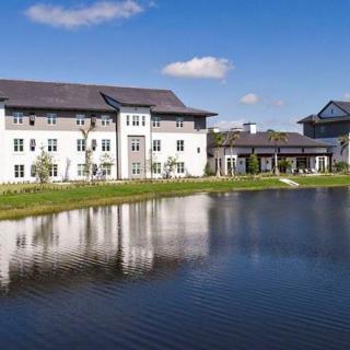 A beautiful building reflected in a serene lake under a clear blue sky.