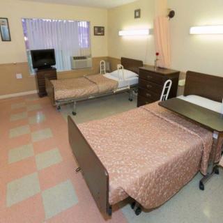 A shared hospital room with two beds and medical equipment.
