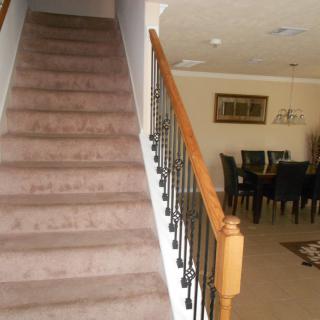 A carpeted staircase leading up beside a dining area with a table and chairs.