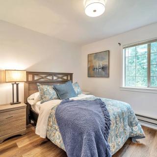 A cozy bedroom with a bed, lamp, and window, featuring wood floors and decorative accents.