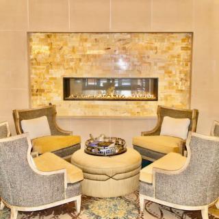 A luxurious and cozy living room with a modern fireplace and elegant seating arrangement.