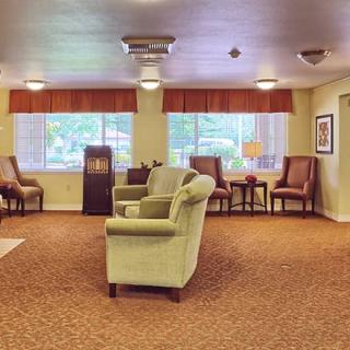 A cozy living room with comfortable seating, large windows, and warm lighting.