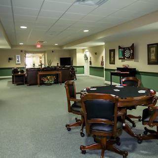 A spacious game room with tables and chairs arranged for leisure activities.