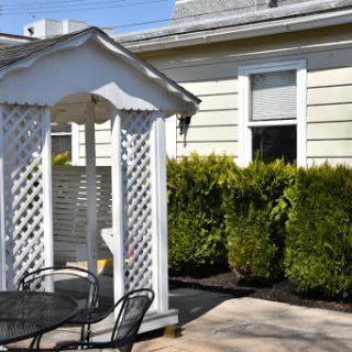 A charming gazebo surrounded by lush greenery in a well-maintained yard.