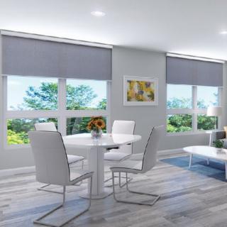 A modern and minimalist living and dining area featuring white furniture, large windows, and an abundance of natural light.