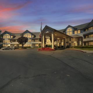 A large building with a welcoming entrance, seen during twilight with a colorful sunset sky.