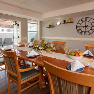 A well-set dining room table with neatly arranged place settings and a decorative centerpiece.