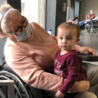 A heartwarming moment between an elderly woman and a young child, sharing a tender connection.