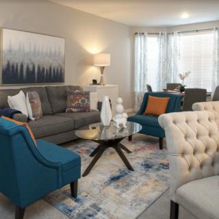 A modern living room with stylish furniture and decor, featuring a sofa, armchairs, and a coffee table.