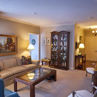 A cozy living room featuring a comfortable sofa, an elegant coffee table, and decorative glass cabinets.