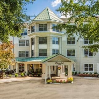 A well-maintained hotel entrance surrounded by trees.