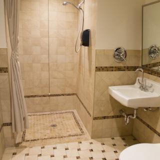 A well-designed bathroom featuring a walk-in shower, sink, and decorative tiles.