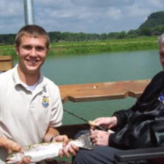 Two people enjoying a fishing trip by the lake.