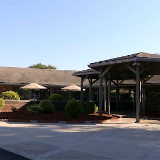 A welcoming entrance to a commercial building featuring outdoor seating and well-maintained landscaping.