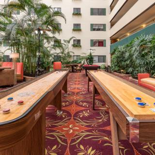 Indoor recreation area with shuffleboard tables and seating.