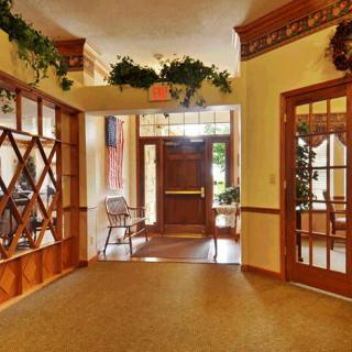 A warmly decorated interior entrance with wooden accents and greenery.