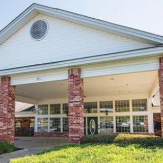 Front view of a building entrance with brick columns and large windows.