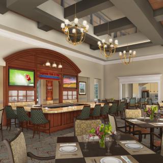 A spacious restaurant interior featuring an elegantly designed dining area with tables and chairs, a bar area, and decorative chandeliers.