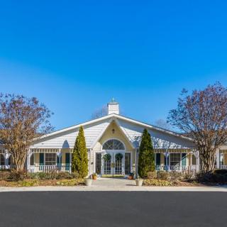 A charming suburban building with trees and a clear blue sky.