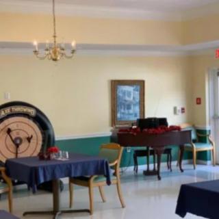 A cozy dining room with tables, chairs, and a piano for entertainment.
