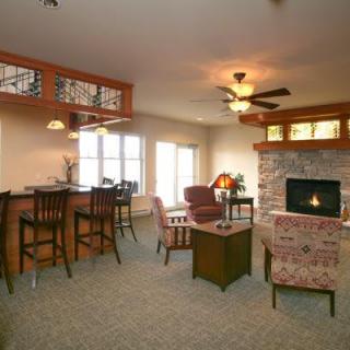 A cozy living room featuring a fireplace, bar area, and comfortable seating.