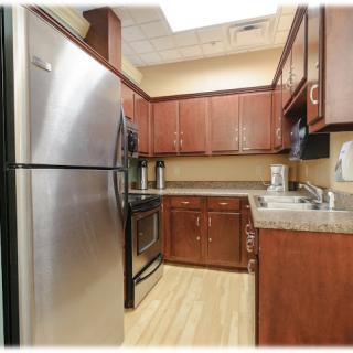 A modern kitchen with stainless steel appliances and wood cabinetry.