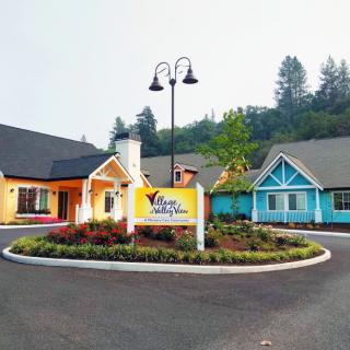 A view of colorful buildings with a landscaped area and sign in front.