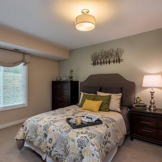 A cozy bedroom with a stylish bed and elegant decor.
