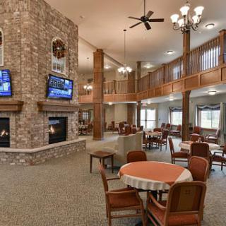 A spacious and cozy lounge area with a fireplace, multiple televisions, and comfortable seating arrangements.
