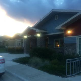 A quiet residential area illuminated by warm lights as the sun sets.