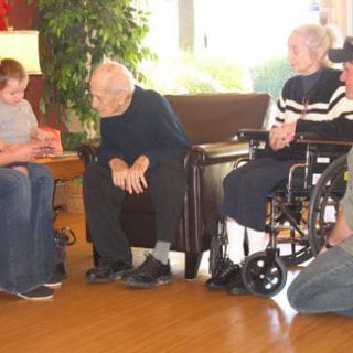 A family gathering with multiple generations engaging in conversation indoors.