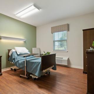 A well-lit hospital room with a bed and minimal furnishings.