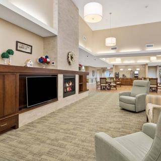 A spacious lounge area featuring comfortable seating, a fireplace, and ambient lighting.