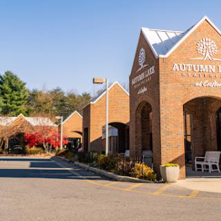 A view of a brick building with a distinctive architectural design, set against an autumn backdrop.