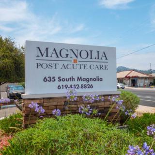 Sign for Magnolia Post Acute Care with surrounding flowers.