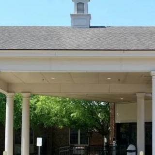 A building entrance with columns and a peaked roof.