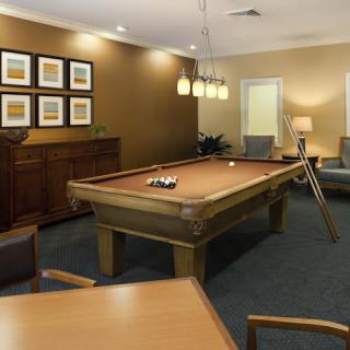 A cozy billiards room featuring a pool table and comfortable seating.