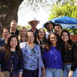 A joyful gathering of friends and family enjoying a sunny day outdoors.