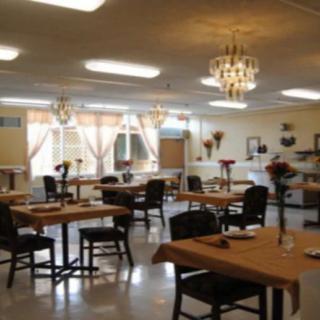 A cozy dining area with neatly arranged tables and elegant chandeliers.