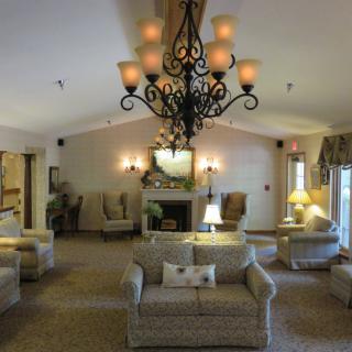 An elegantly decorated living room featuring a large chandelier, multiple sofas, and a fireplace.