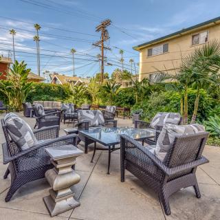 A cozy outdoor patio with comfortable seating and lush greenery.