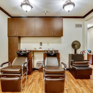 A cozy hair salon featuring styling chairs and a warm interior atmosphere.