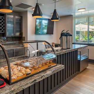 A modern cafe interior with a bakery display and coffee station.