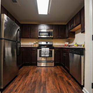A modern kitchen with stainless steel appliances and dark wood cabinets.
