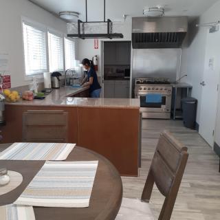 A well-equipped modern kitchen with a person preparing food.