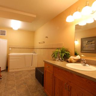 A well-lit bathroom with a sink, mirror, and integrated laundry area.