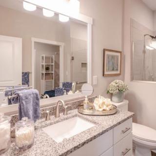A well-decorated bathroom with a granite countertop and mirror.