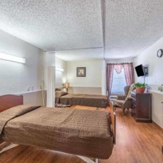 A spacious hospital room designed for patient comfort, featuring two beds and essential furnishings.